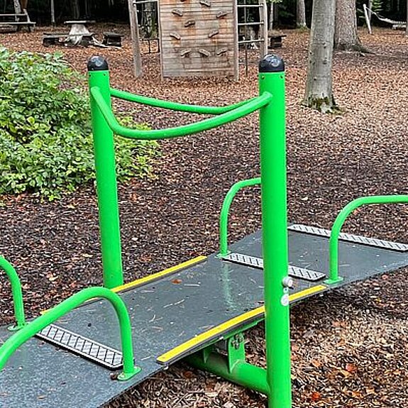 Bunte Spielgeräte in einem Wald.