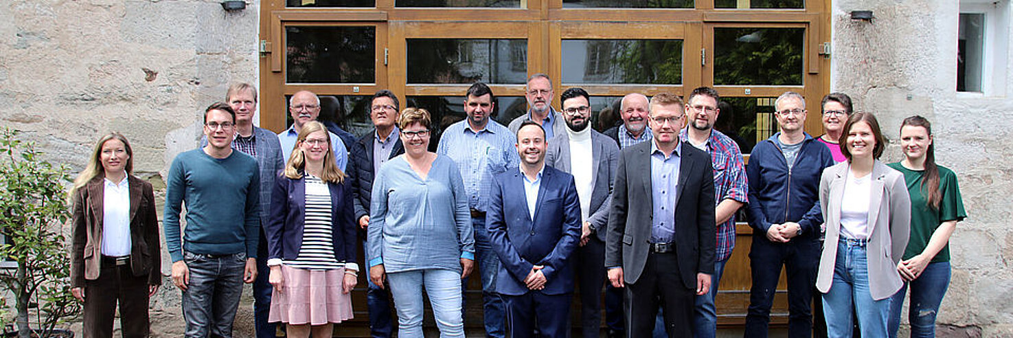 Gruppe von Personen vor einer Holztür